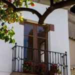 Ein Fenster mit Orangenbaum im Vordergrund